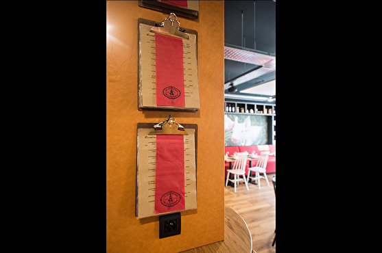 La carte du restaurant est présentée de façon originale (anciens support pour écrire) et suspendue à un mur.