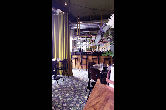 La Raffinerie au style contemporain possède un bar vintage, une moquette à motif floral et des chaises anciennes.