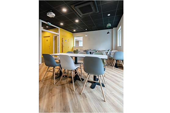 Aménagement de la salle de restaurant : mobilier design et couleur vive au mur