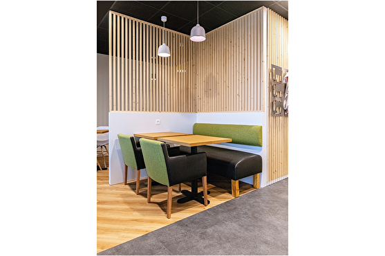 Séparation des espaces : cloisons modernes en bois clair. Assises (banquettes et chaises) modernes, de couleur verte
