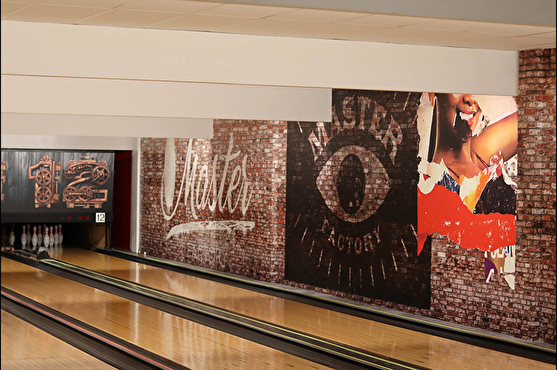 Le long des pistes de bowling, le mur en effet "brique" avec le nom stylisé du bowling offre une ambiance moderne et urbaine