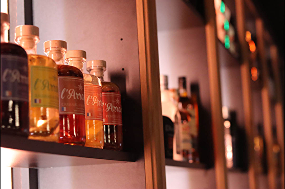 Photographie des bouteilles de rhum arrangé alignées derrière le bar