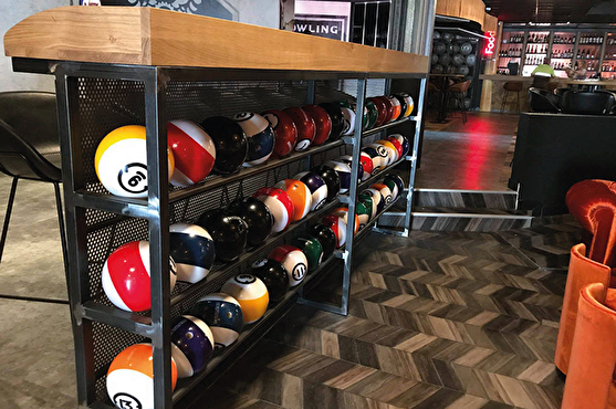 Les boules de bowling sont rangées sur une étagère métallique moderne