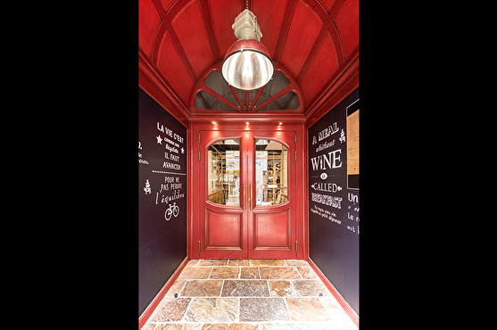 L'entrée du restaurant est rouge et classe, le sol est en pières et des citations sont écrites sur les murs.