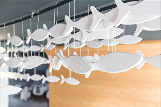 Des poissons blancs suspendus au plafond décorent le restaurant et rappellent le thème de la mer.