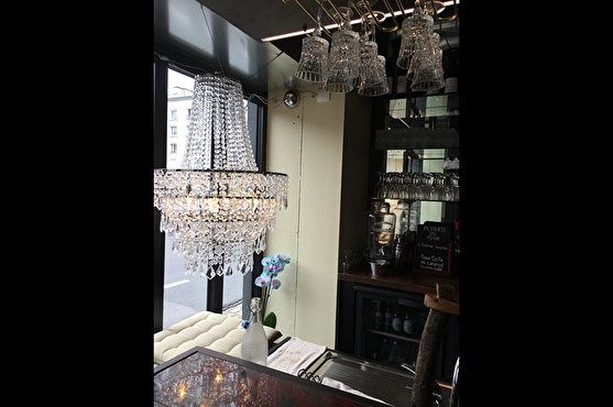 Derrière le comptoir du bar, dans la vitrine du restaurant, se trouve un lustre suspendu en cristal.