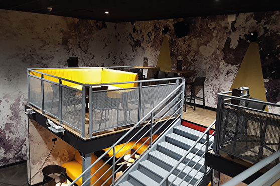 Aménagement d'une mezzanine moderne : banquettes jaunes et chaises hautes grises