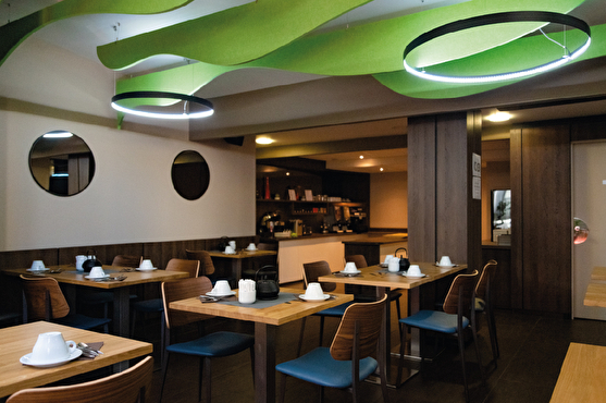 Décoration moderne de la salle de restauration : couleurs sobres et une touche de couleur au plafond avec des vagues acoustiques vertes pomme